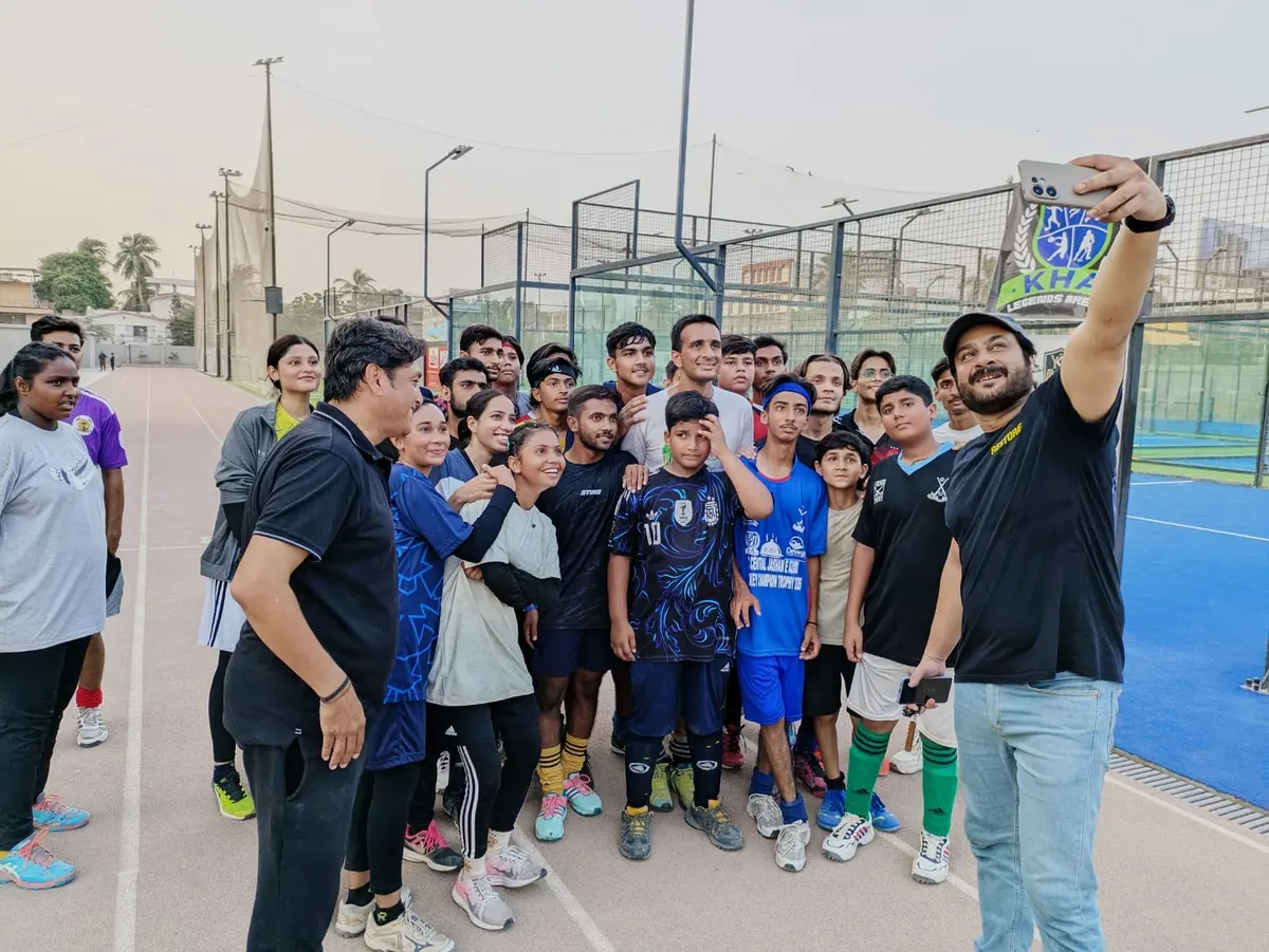 Kamran Jilani taking a selfie with smiling young players and a coach
